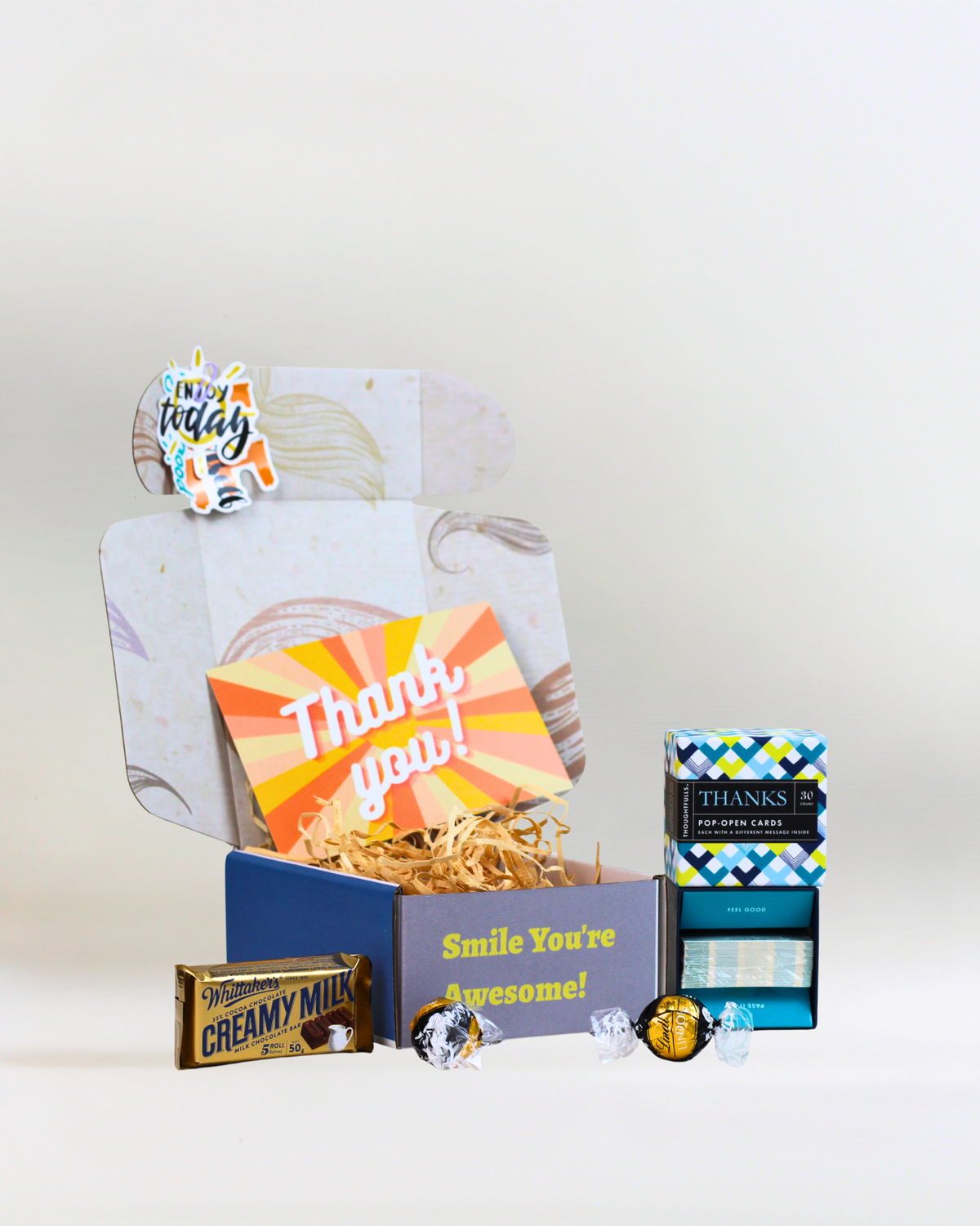A Little Box of Thanks gift box featuring Compendium 30-card thank you card set, Whittaker's Creamy Milk Chocolate, two Lindt Lindor Dark Chocolate Moments and a personalised gift card in A Box-Full signature packaging.