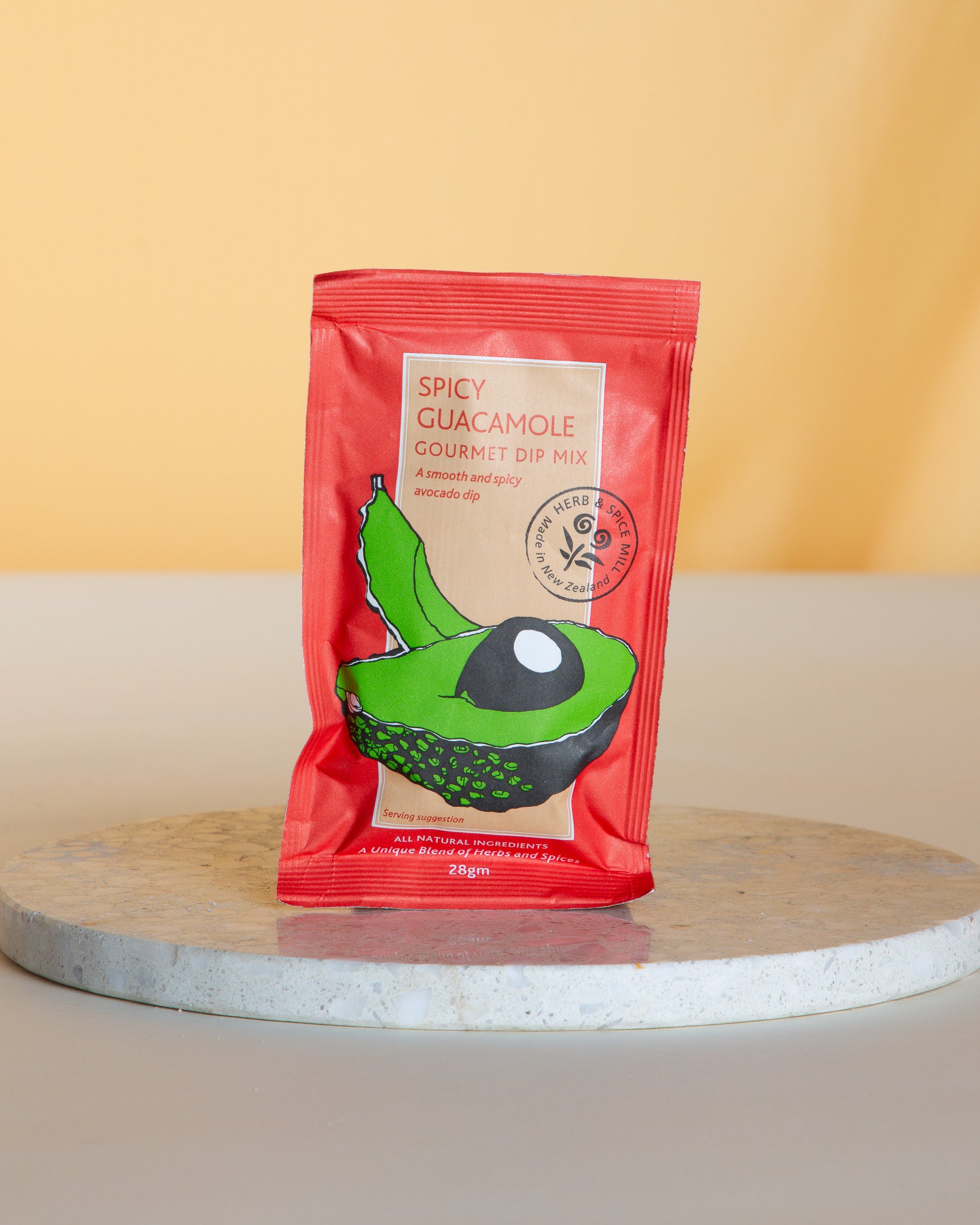 Spicy Guacamole gourmet dip mix package on a round marble slab 