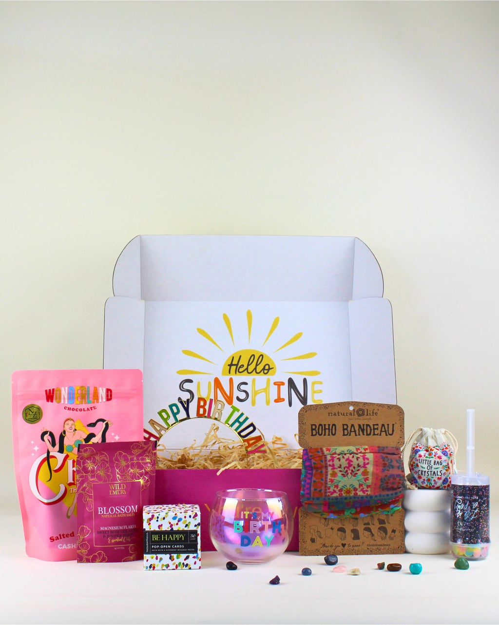 Bright and joyful Birthday Smiles Box – a colourful, uplifting birthday gift box in NZ. Includes a Happy Birthday roly-poly glass, Wild Emery bath salts, mixed crystal bag, salted caramel chews, birthday headband, inspiring pop-open cards, and a Natural Life boho bandana. Perfect positive gift for friends, daughters, sisters, teens, and workmates who love cheerful, feel-good surprises.