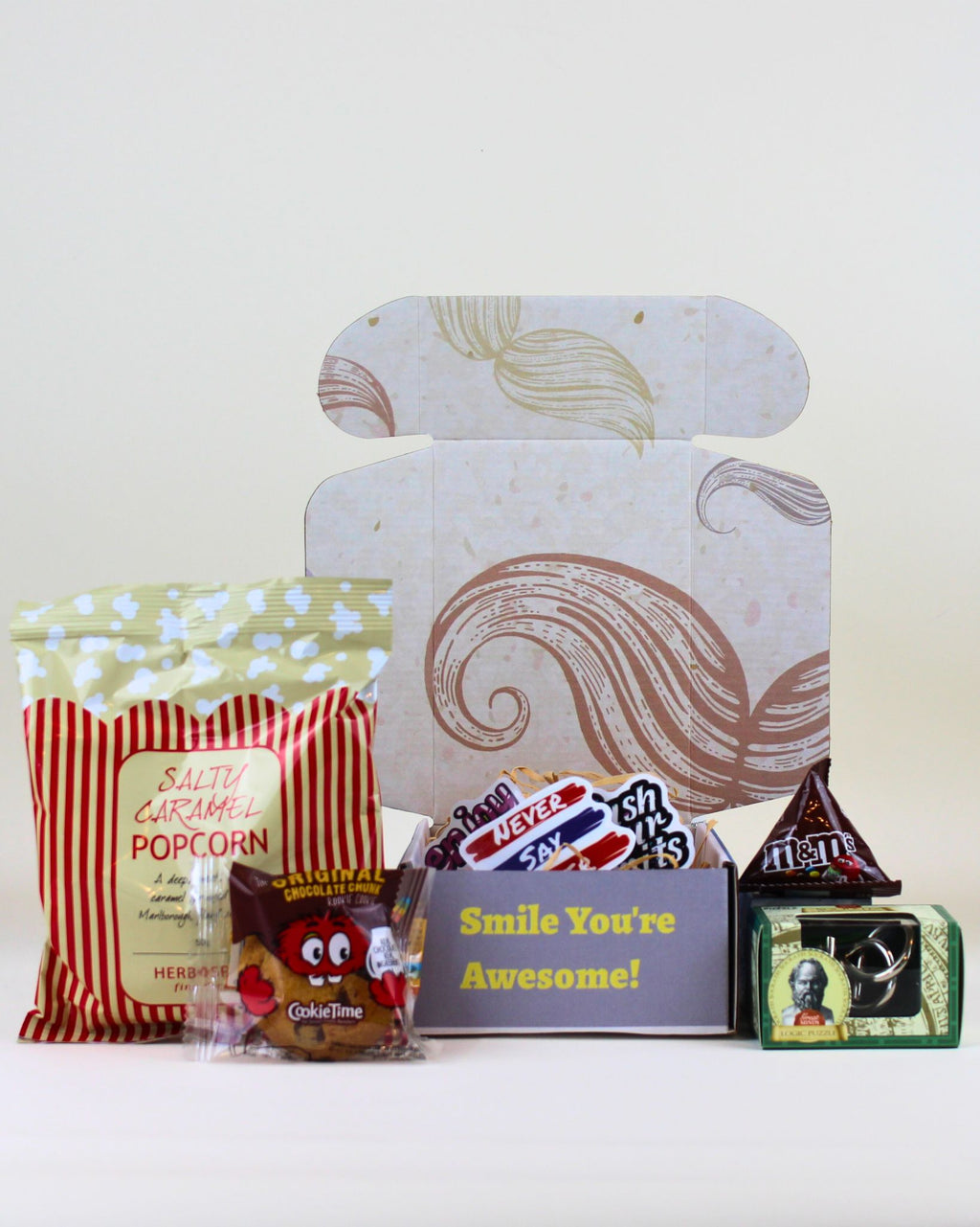 Budget Friendly Gift Box from A Box-Full featuring a moustache keepsake box, Socrates logic puzzle, M&M's, Cookie Time cookie, affirmation stickers and personalised card.