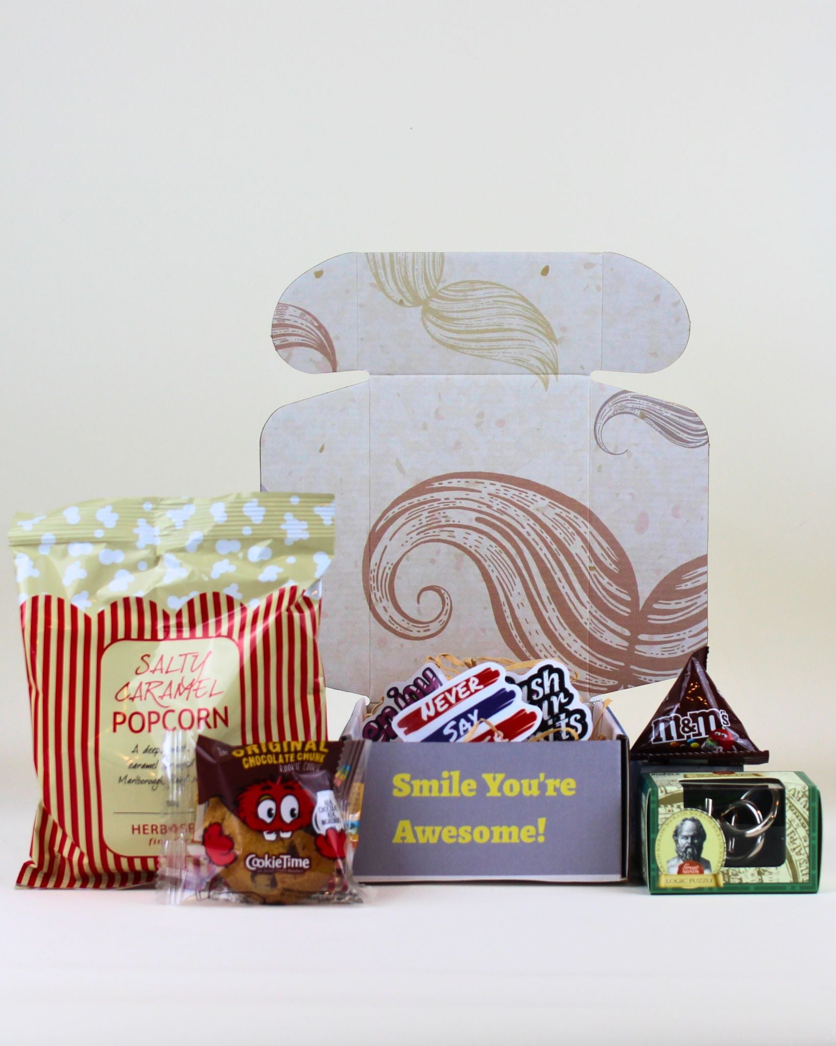 Budget Friendly Gift Box from A Box-Full featuring a moustache keepsake box, Socrates logic puzzle, M&M's, Cookie Time cookie, affirmation stickers and personalised card.