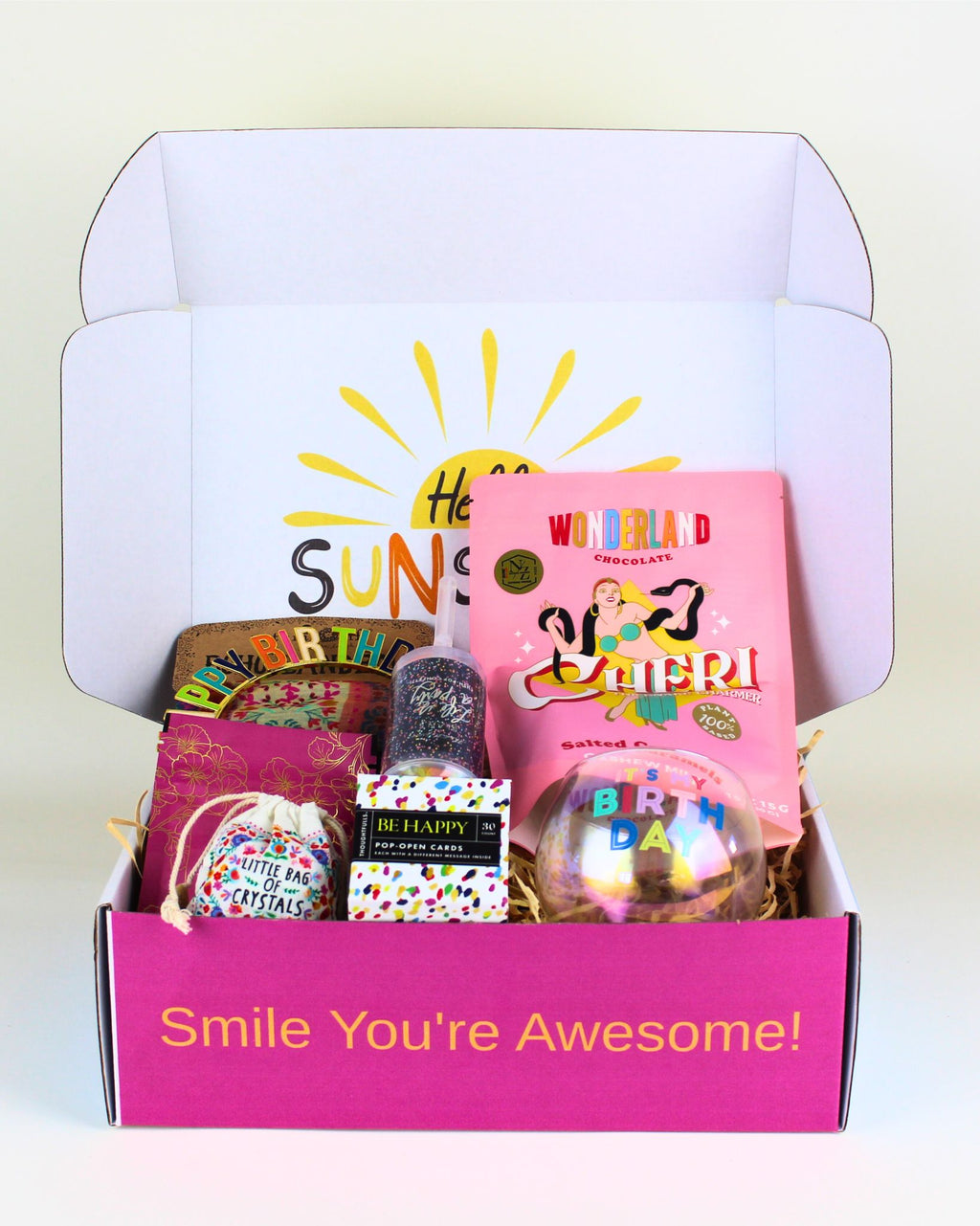 Cheerful and uplifting Birthday Smiles Box – a vibrant birthday gift box in NZ filled with a Happy Birthday roly-poly glass, Wild Emery bath salts, crystal mix, salted caramel chews, birthday headband, positive pop-open cards, and a Natural Life boho bandana. A fun, colourful gift for teens, friends, sisters, and anyone who loves bright, feel-good surprises.