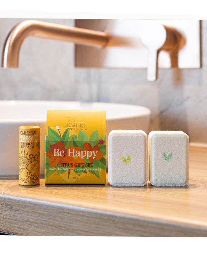 Wild Emery natural lip balm with chamomile and coconut, paired with Be Happy shower steamers, perfect gifts for her in NZ for a joyful self-care ritual.