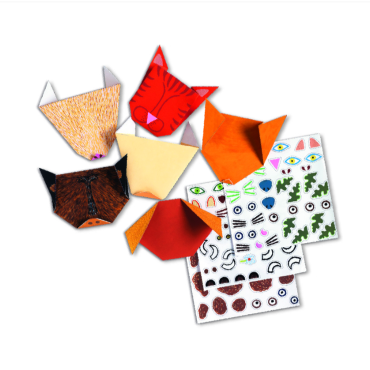 A set of origami cat faces made from colored paper, arranged around two sheets of decorative stickers with eyes, ears, whiskers, and animal motifs. 
