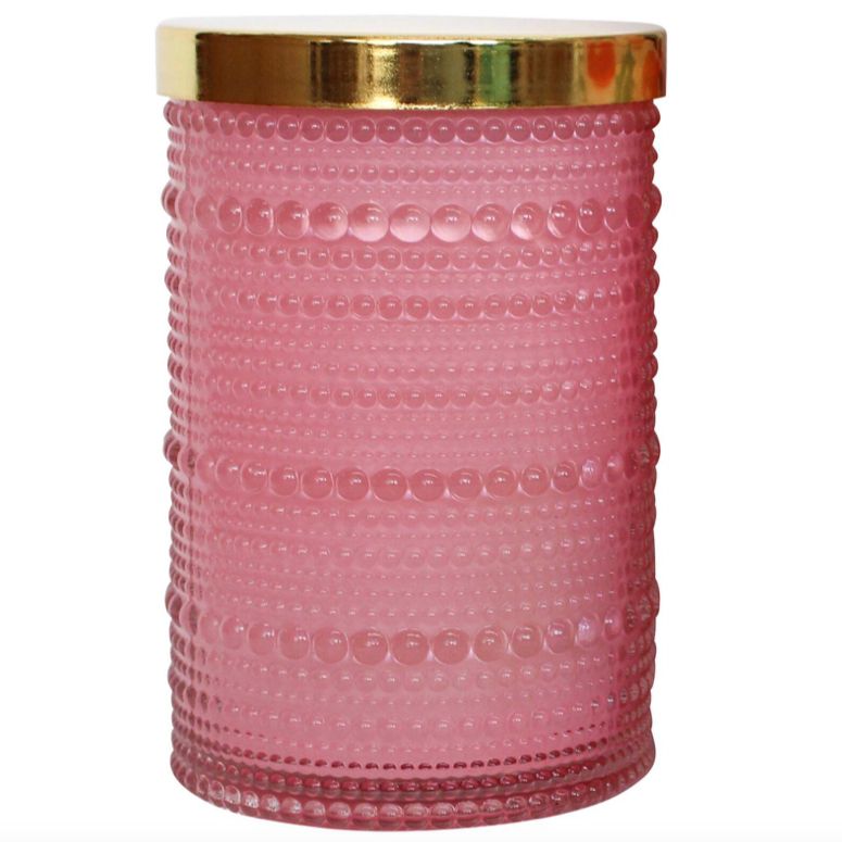 An elegant scented candle presented in a chic pink jar, styled on a neutral surface to highlight its minimalist design. The candle features a smooth finish and modern aesthetic, ideal for gifting or enhancing home décor with a touch of luxury.