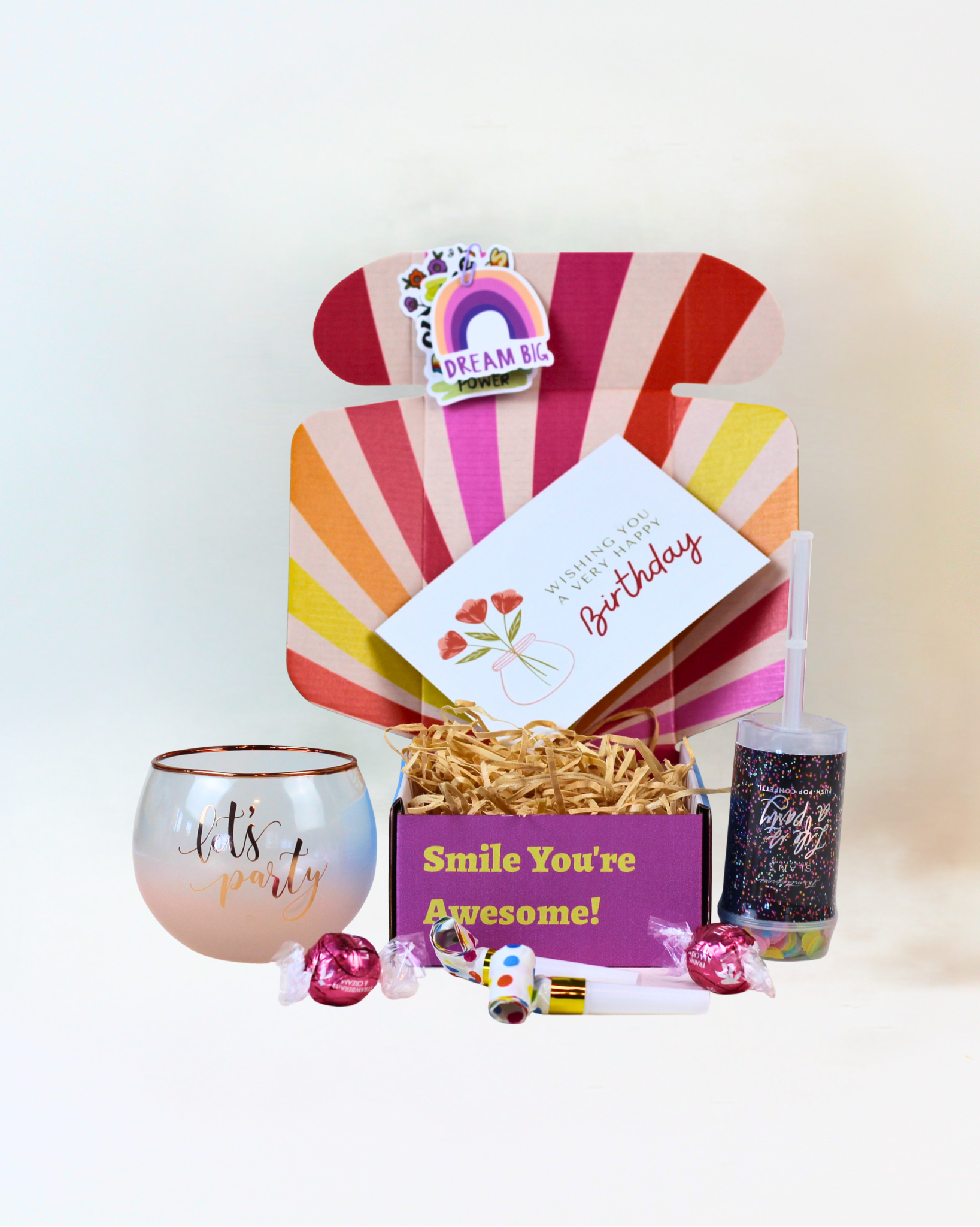 Let's Party Gift Box featuring a choice of Happy Birthday or Let's Party Roly Poly glass, party popper, party blowers, Lindt Lindor chocolates, personalised gift card and uplifting affirmation card, beautifully presented for gifting.