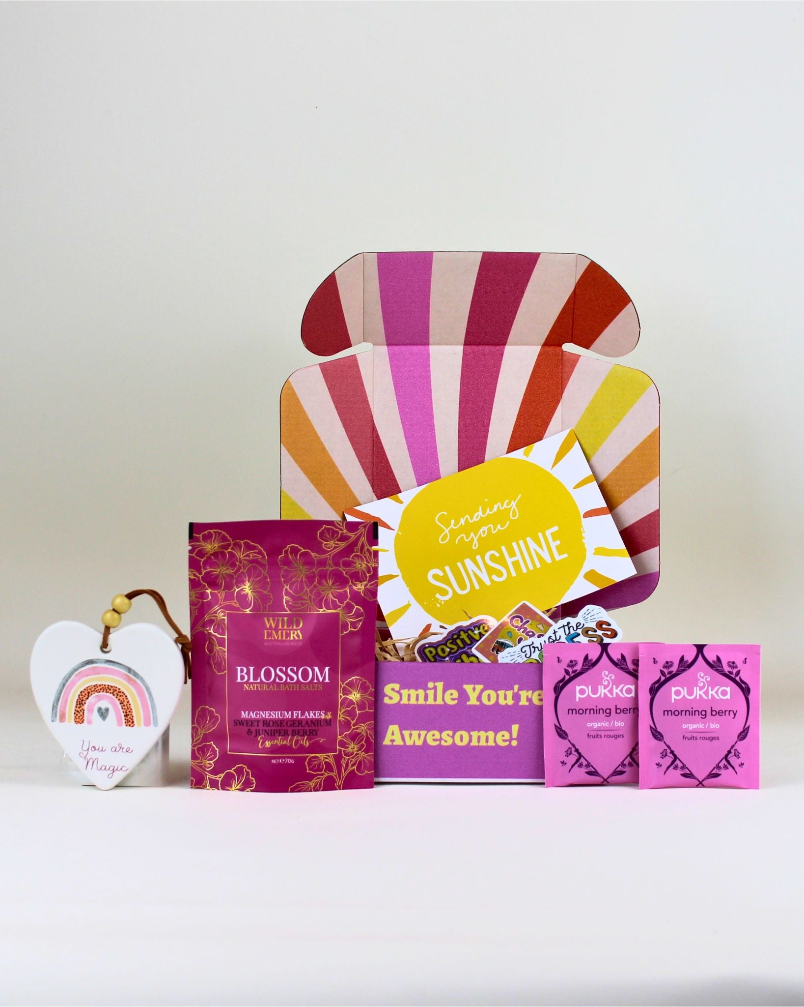 A beautifully presented NZ gift box for her featuring a heart keepsake, berry tea, natural bath salts, affirmation stickers, and a personalised card in a colourful “Smile, You Are Awesome” box.
