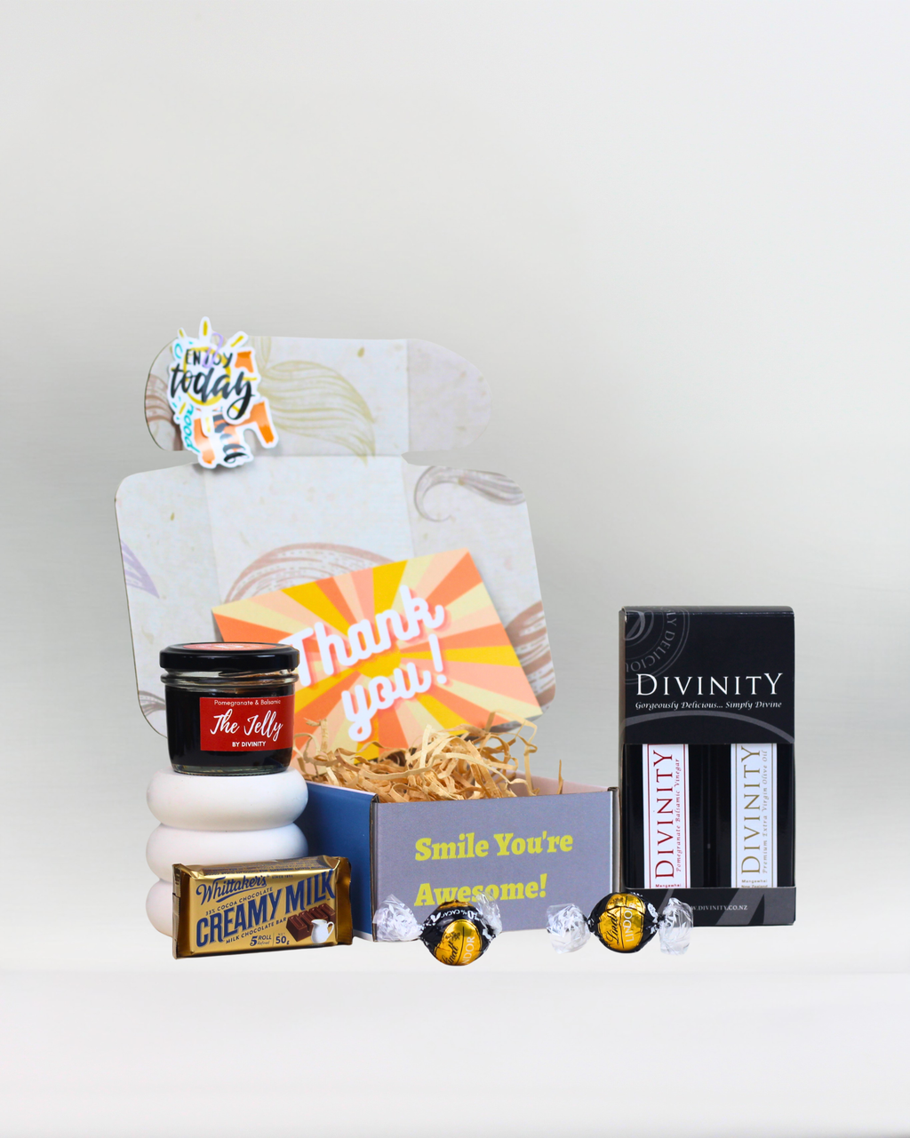 Little Taste of Luxury gourmet gift box featuring Divinity pomegranate balsamic vinegar, premium extra virgin olive oil, pomegranate and balsamic jelly, Lindt Lindor dark chocolate moments, Whittaker's Creamy Milk Chocolate and a personalised gift card in an A Box-Full signature gift box.