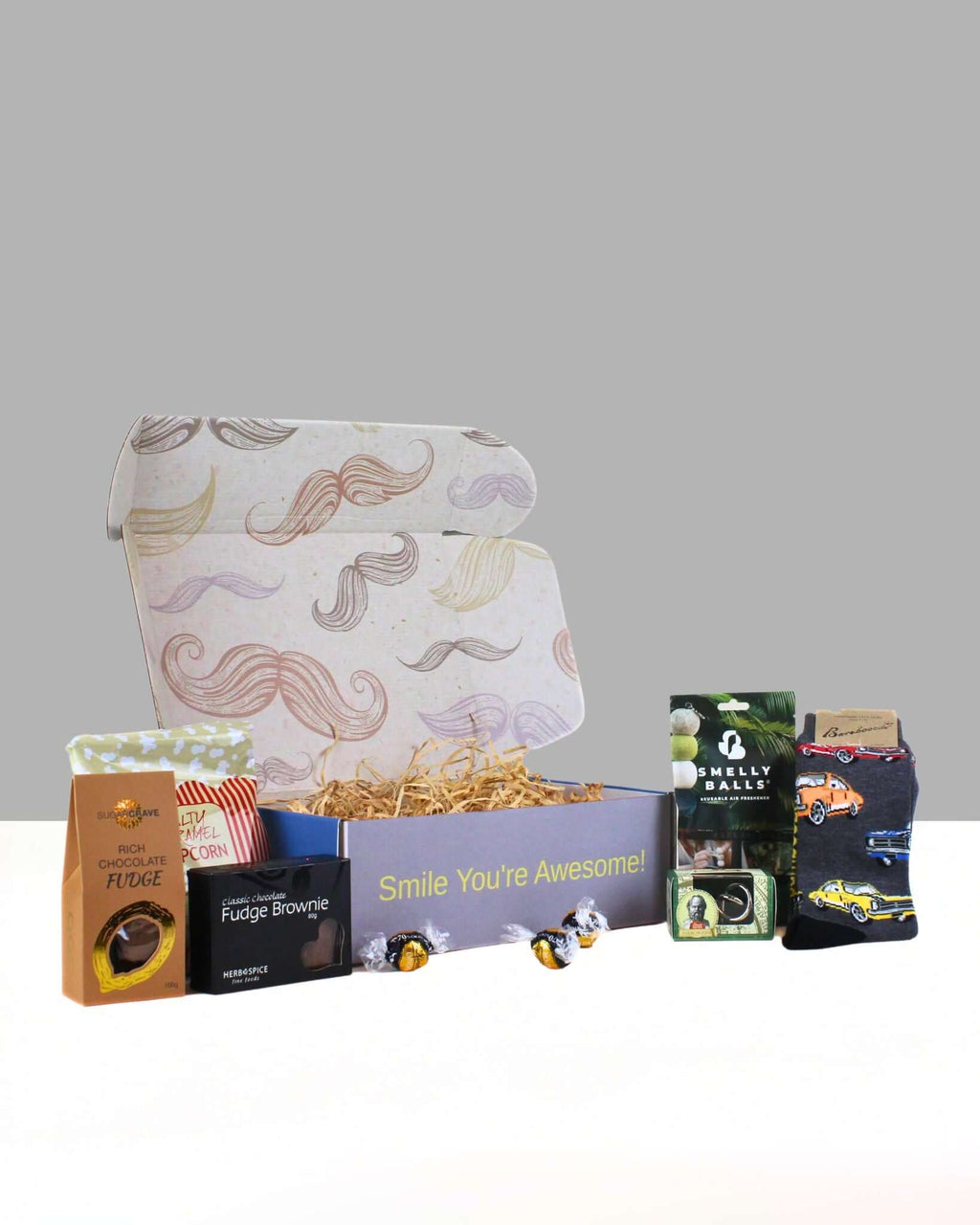 Gift Box For Him In NZ with Smelly Balls car air freshener, Bamboozld car socks, brain teaser puzzle, and NZ-made treats in a men’s gift box.