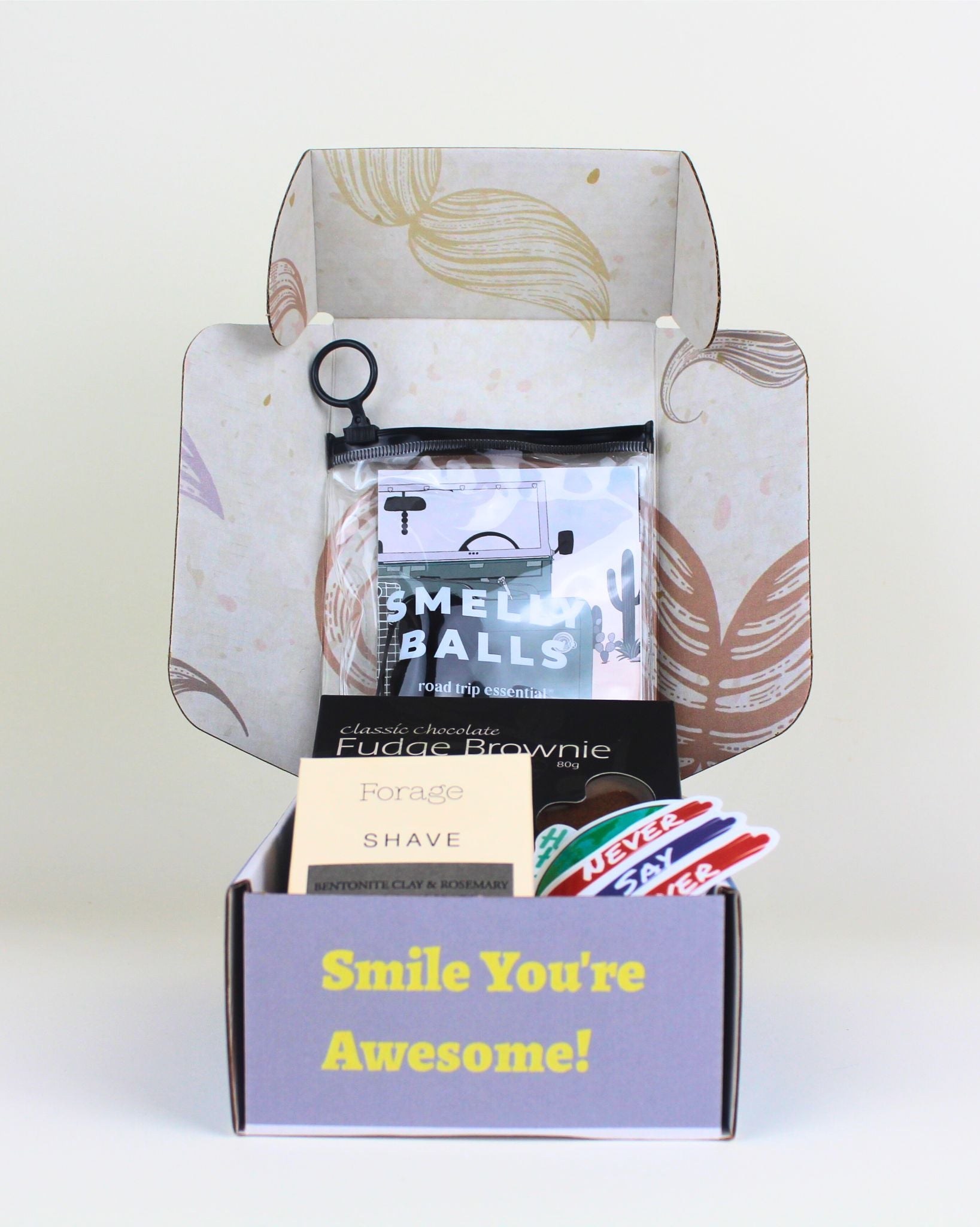 A unique small men’s gift box NZ with Smelly Balls car freshener, natural shave bar by Forage, Herb & Spice brownie and fun moustache packaging.